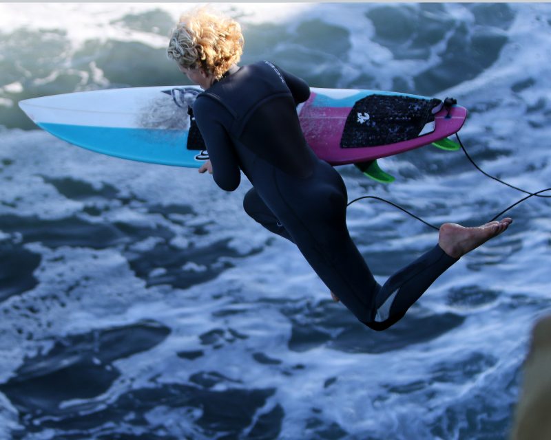 Leaping female surfer